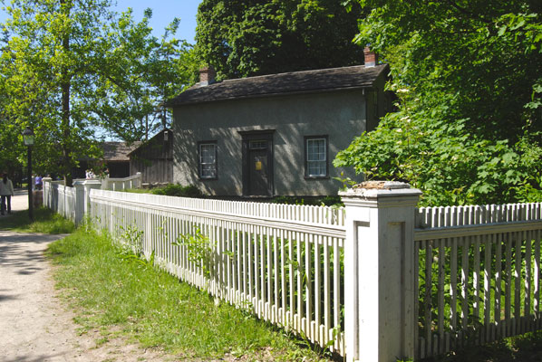a house in the village with a white picket fence