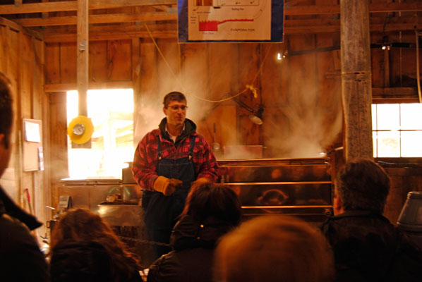 a man demonstrates the modern method for making maple syrup inside the sugar shack