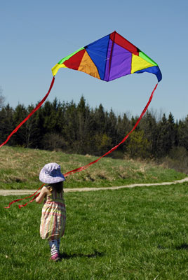 a little girl and a colourful kite