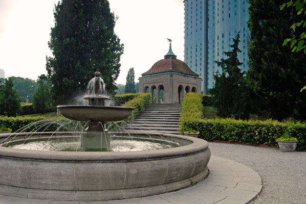 a view of a fountain in Oakes Garden Theatre with a stone pavilion in the distance
